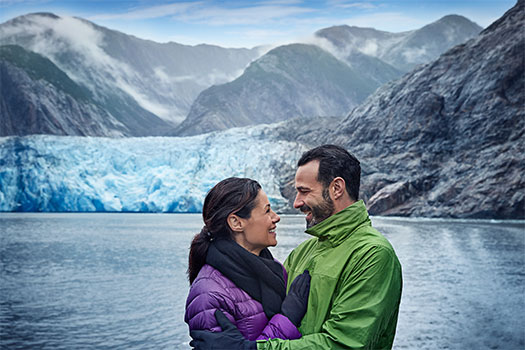 Pareja disfrutando de un glaciar de Alaska. SoloCruceros.mx