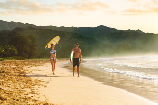 Pareja disfrutando de la playa y las olas, Hawái. SoloCruceros.mx